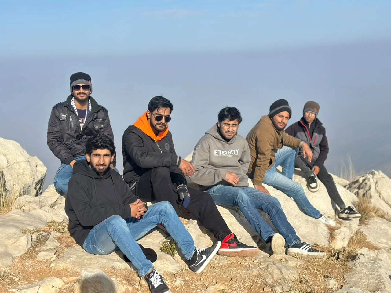 Friends sitting together on a rocky mountaintop
